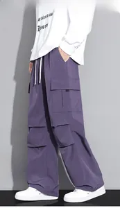 Detail view of purple cargo pants showing side utility pockets and drawstring waist