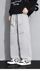 Détail du pantalon cargo gris clair avec cordon de serrage et patchwork géométrique