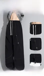 Détail du pantalon cargo avec cordon, coutures contrastées et coupe ample décontractée