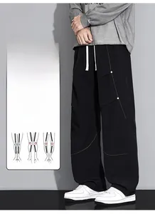 Détail du pantalon cargo noir avec taille à cordon blanc et surpiqûres visibles