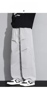 Détail du pantalon cargo gris clair avec coupe large et cordon de serrage blanc à la taille