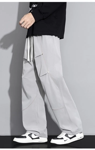 Détail du pantalon cargo gris clair avec plis latéraux et coutures contrastées