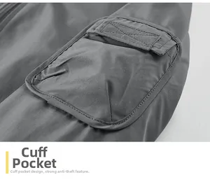 Detailed close-up of a reinforced utility sleeve pocket on a dark gray worker jacket