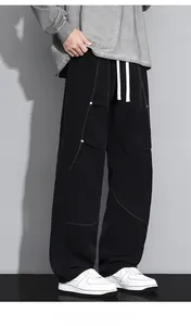 Détail du pantalon cargo pour hommes avec coutures orange et rivets métalliques