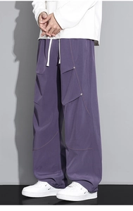 Détails du pantalon cargo violet avec coutures asymétriques et décorations de rivets