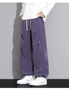 Détail du pantalon cargo violet avec surpiqûres orange contrastées et rivets stylés