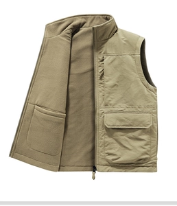Detail of khaki outdoor vest showing zipper pockets and warm brown fleece lining