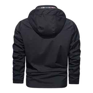 Detail view of black outdoor hooded jacket showing red and blue plaid lining and cuffs