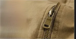 Close-up of vintage metal zipper and khaki cotton fabric texture on work jacket