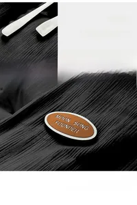 Macro detail of corduroy jacket texture featuring a branded brown patch and white drawstrings