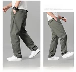 Détail du pantalon en coton sergé vert olive avec poches latérales et poche arrière boutonnée