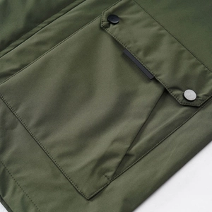 Detailed view of army green outdoor jacket featuring cargo pocket with matte snap buttons