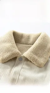 Detailed view of corduroy jacket with thick faux shearling collar and metal button