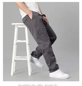 Détail de la texture sergé gris foncé et bouton de poche latérale du pantalon homme