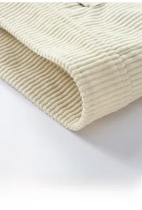 Close-up of beige corduroy jacket hem with thick ribbed cuffs and textured fabric