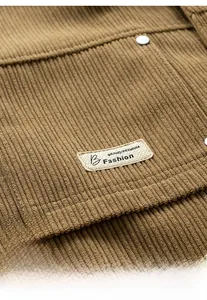 Detail of warm brown corduroy jacket featuring a stitched pocket and silver metal rivet