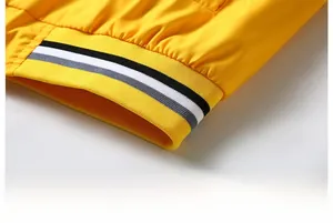 Detail of yellow sports jacket featuring ribbed hem with black and white stripes