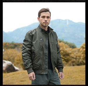 Detailed close-up of tactical olive green bomber jacket with eagle patch and metal zippers