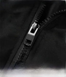 Detailed macro view of the durable matte metal zipper and fabric texture of the black jacket
