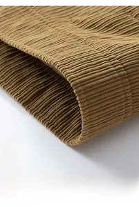 Detail view of the brown corduroy jacket hem showing vertical texture and stitching