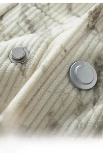 Vue macro des boutons argentés et de la texture velours côtelé de la veste d'hiver