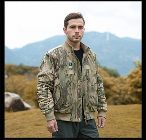 Detail of army green camouflage bomber jacket with tactical patches and ribbed cuffs