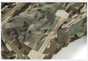 Detail of multicamo tactical pilot jacket showing velcro pockets and durable metal zipper
