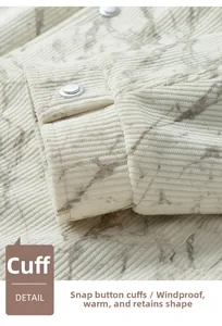 Détail du poignet d'une veste en velours blanc avec motif marbré et bouton en métal