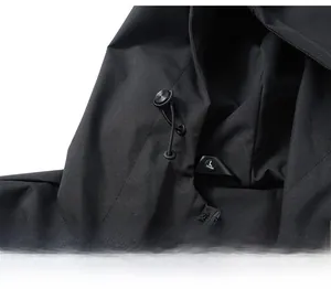 Detail of adjustable drawstring with metal toggles on black hooded waterproof jacket
