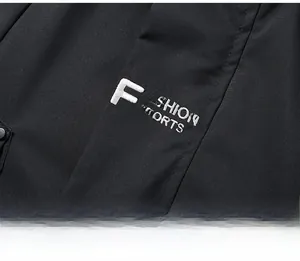 Close-up of white Fashion Sports embroidery on black waterproof windbreaker jacket