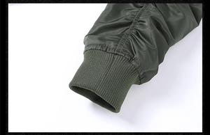 Detail of army green flight jacket sleeve with pleated seam and ribbed knit cuffs