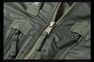 Detail of army green tactical jacket with brass zipper and Special Forces badge