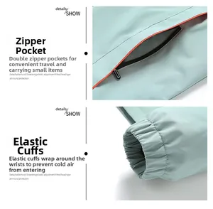 Detail of light green jacket featuring orange zipper pockets and elastic windproof cuffs