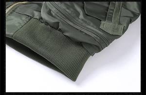 Close-up of military green bomber jacket featuring windproof nylon and ribbed hem
