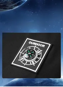 Detail shot of the integrated compass on a waterproof outdoor jacket with logo detail
