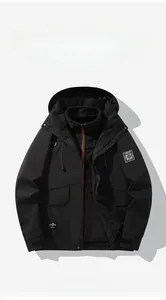 Detailed flat lay of a black 3-in-1 waterproof outdoor jacket with adjustable hood