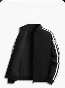 Detail of black stand collar jacket featuring white side stripes and ribbed cuffs