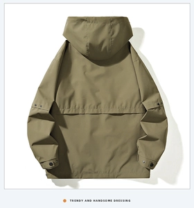 Detail view of the back of a green windbreaker jacket with adjustable snap cuffs