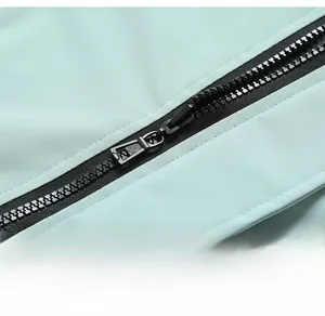 Detailed close-up of a durable black zipper on a mint green casual sports jacket