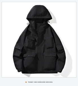 Detailed view of the four large utility pockets on this black hooded tactical jacket