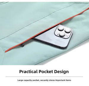 Detail of mint green jacket zip pocket with orange trim and large storage space