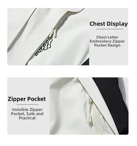 Detail of outdoor jacket with white and black panels, embroidery and zip pocket