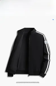 Detail of black sports jacket featuring parallel white shoulder stripes and stand collar