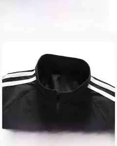 Detail view of stylish stand collar and white shoulder stripes on black sports jacket