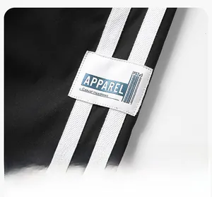 Detail view of black jacket sleeve featuring white stripes and Apparel woven label