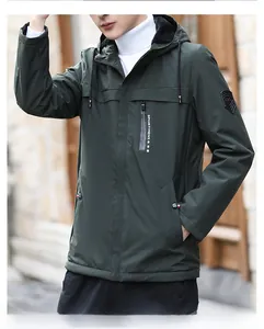 Close-up of waterproof zipper pocket and brand patch on green hooded outdoor jacket
