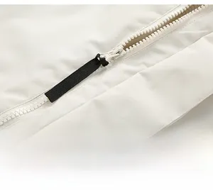 Detail of smooth white plastic zipper and black fabric puller on a winter jacket