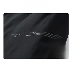 Detail view of durable black tech fabric with reflective Sport lettering and composite layers