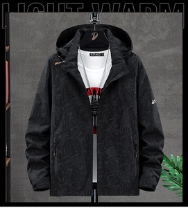 Detailed view of dark grey hooded jacket featuring subtle leaf pattern and full zipper closure
