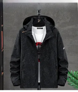 Detail of black hooded jacket featuring leaf pattern texture and zipper pockets